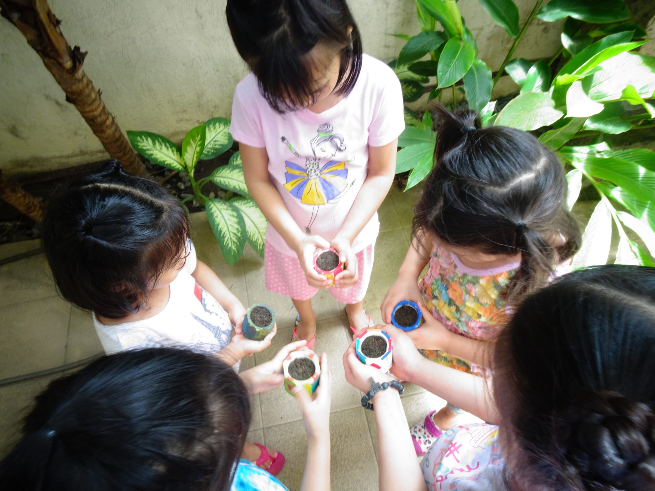 girls planting activity gathered in a circle